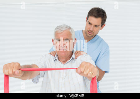 Physiothérapeute masculin senior massage mans retour à la medical office Banque D'Images