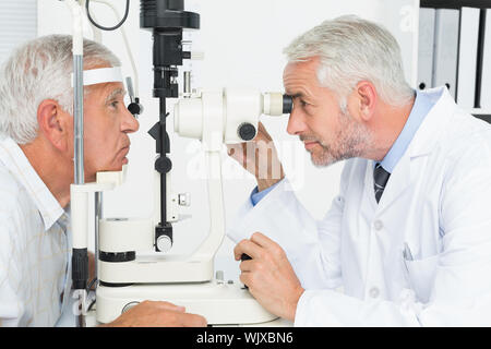 Vue latérale d'un optométriste pour examen de la vue fait senior patient Banque D'Images