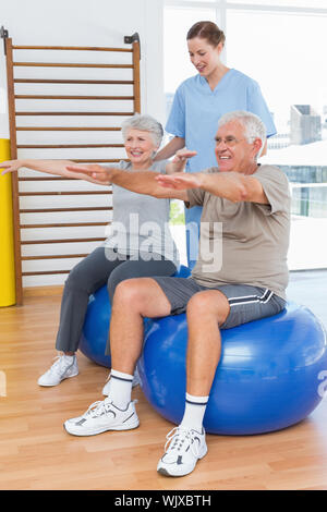 Female therapist aider senior couple avec des exercices dans le bureau médical Banque D'Images