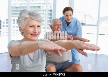 Female therapist aider senior couple avec des exercices dans le bureau médical Banque D'Images