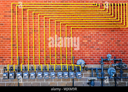 Ligne de gaz naturel avec tuyaux jaune sur la construction de mur de brique Banque D'Images