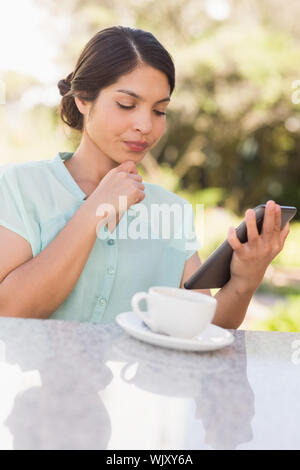 Businesswoman having coffee et de travail sur tablet pc dans le patio du restaurant Banque D'Images