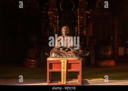 DEC 3, 2018 Yamagata, Japon - Nenbutsu hall ancienne en bois Bouddha statue moine sur table en bois sous la lumière chaude soirée à Yamadera Risshaku ji Banque D'Images