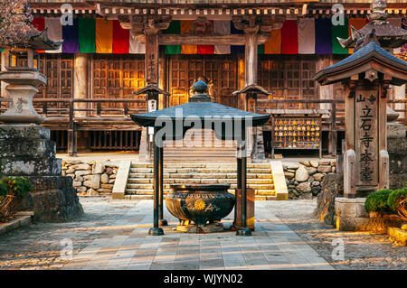 DEC 3, 2018 Yamagata, Japon - Hall principal Konponchudo inscent pot dans Yamadera Risshaku ji avec de vieux mur en bois et coloré des drapeaux du bouddhisme Banque D'Images