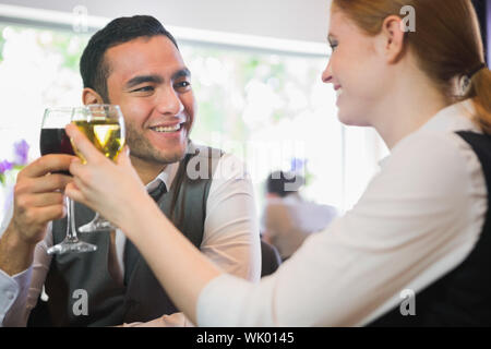 Smiling business partners tintement des verres à vin Banque D'Images