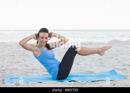 Woman doing abdominal crunches on exercise mat Banque D'Images