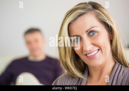 Femme souriante avec son mari dans l'arrière-plan Banque D'Images