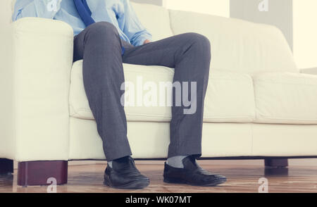 Partie basse de classy businessman sitting on cosy sofa Banque D'Images