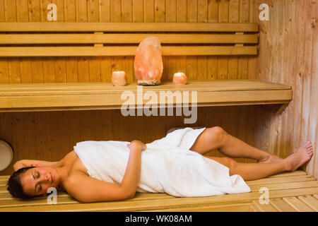 Happy brunette woman lying in a sauna Banque D'Images