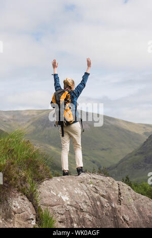 Femme debout sur le rocher après une randonnée d'encouragement Banque D'Images