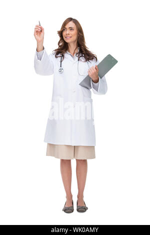 Brunette doctor holding clipboard and pointing at something Banque D'Images