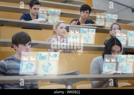 Les étudiants ciblés dans la salle de conférences de travailler sur leur tablette futuriste Banque D'Images