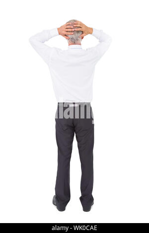 Businessman standing back to camera with hands on head Banque D'Images