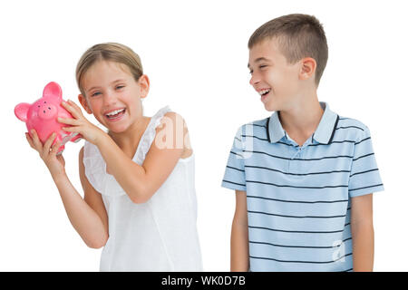 Smiling young girl holding piggy bank Banque D'Images