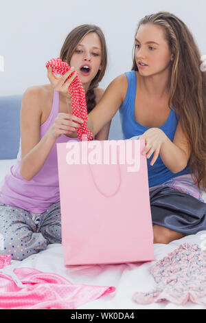 Girls sitting in bed after shopping Banque D'Images