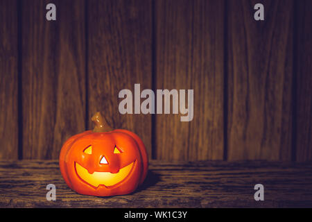 Citrouilles d'Halloween jack o lanterne avec grimaces sur bois grunge de nuit. Fond d'Halloween avec l'exemplaire de l'espace pour votre texte publicitaire Banque D'Images