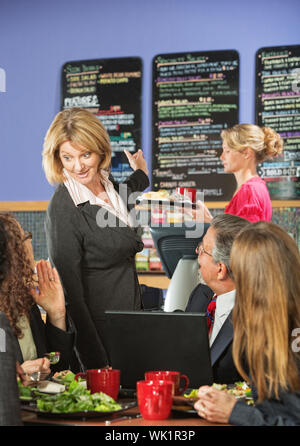 Cafe propriétaire parle de menu avec groupe de clients Banque D'Images