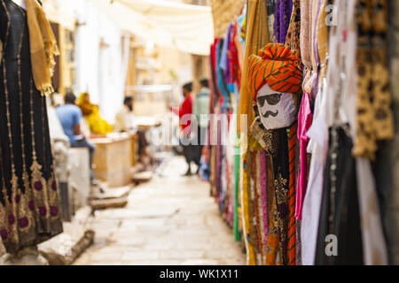 (Selective focus) belle boutique avec des vêtements traditionnels indiens (SARI) et un masque représentant le visage d'une personne du Rajasthan. Jaisalmer, Inde Banque D'Images