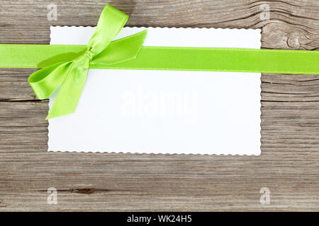 Feuille de papier vierge avec l'arc vert sur fond de bois Banque D'Images