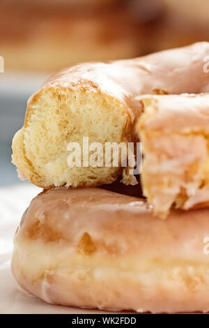 Plateau de donuts glacé avec en-cas manquants. L'extrême profondeur de champ avec selective focus on partie de donut qui a été mordu. Banque D'Images