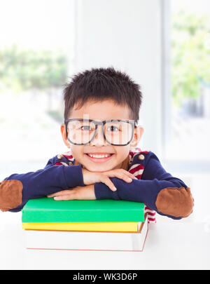 Smiling little boy lying on books Banque D'Images