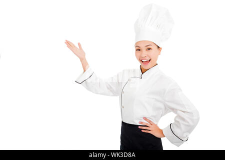 Jeune femme cuisinière lever les mains pour montrer quelque chose Banque D'Images