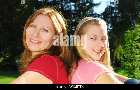 Portrait of smiling mother and daughter in summer park Banque D'Images