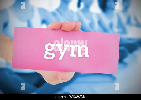 Woman holding carte rose disant sport contre yoga class in gym Banque D'Images