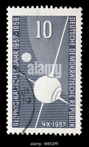 Timbre émis en Allemagne - République Démocratique (DDR) montre satellite artificiel Spoutnik I, partie de la terre, la lune, l'année de géophysique, vers 1957. Banque D'Images