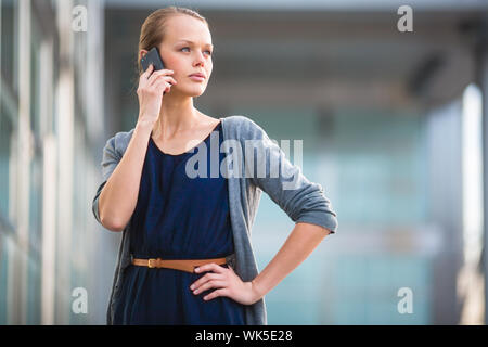 Portrait d'une jeune femme appelant sur un smartphone dans un contexte urbain/ville (shallow DOF ; couleur tonique libre) Banque D'Images
