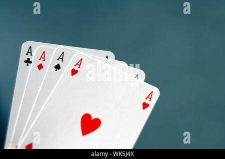Main tenant quatre As avec bokeh copyspace Banque D'Images