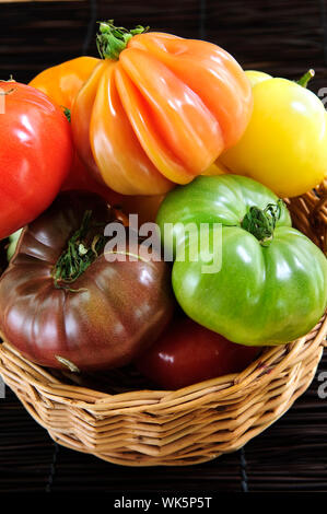 Panier en osier plein de multi colored heirloom tomatoes Banque D'Images