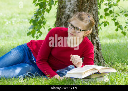 Young Girl reading book in park au printemps Banque D'Images