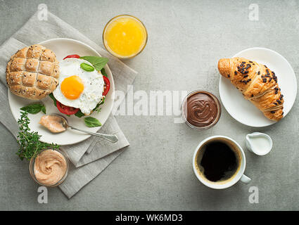 Petit-déjeuner servi avec du jus d'orange, un sandwich avec des œufs, des croissants et du café. Délicieux petit déjeuner sain. Banque D'Images