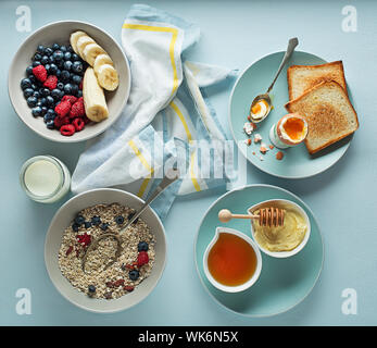 Petit-déjeuner servi à l'avoine et les fruits, oeuf mollet, miel et beurre. Délicieux petit déjeuner sain. Banque D'Images