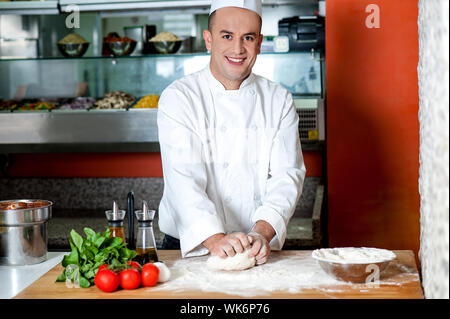 Young male chef preparing pizza Banque D'Images