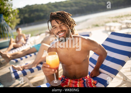 Beau basané barbu man holding glass with cocktail Banque D'Images