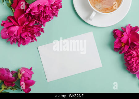 Carte vierge mock-up sur la table avec de belles pivoines et tasse de café Banque D'Images