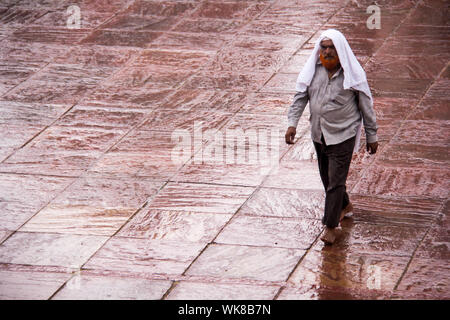 Homme marchant sur sol humide dans une mosquée, Jama Masjid, Old Delhi, Inde Banque D'Images