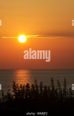 Beau Soleil colorés au-dessus de l'océan avec les vagues. Muriwai Colonie de Fou de Bassan, près de Auckland, île du Nord Nouvelle-zélande Banque D'Images