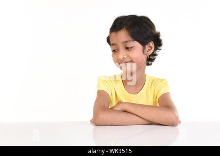 Fille assise à une table Banque D'Images