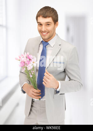 Bel homme avec des fleurs à la main Banque D'Images
