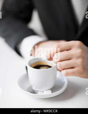 Mettre le sucre dans le café de l'homme Banque D'Images