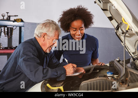 Location de maître et femme africaine en tant qu'apprenti à la mécatronique d'inspection automatique Banque D'Images
