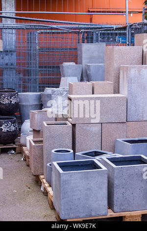 Céramique émaillé et pots de fleur dans une variété de tailles et couleurs empilés sur des palettes en bois à l'extérieur d'une poterie, entrepôt ou commercial magasin Banque D'Images