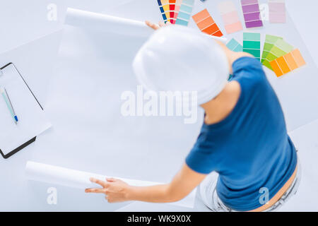 Architecture, design d'intérieur et rénovation concept - femme en travaillant avec des échantillons de couleur du casque et du plan directeur Banque D'Images