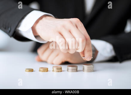 Man putting pile de pièces dans une ligne Banque D'Images