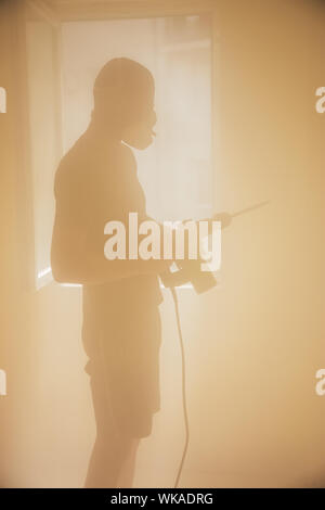 Travailleur avec marteau, briser le mur intérieur de plâtrage. Banque D'Images