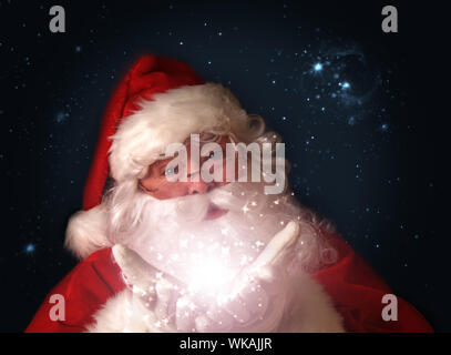 Santa avec les lumières de Noël magique dans les mains Banque D'Images