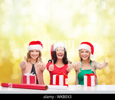 Noël, x-mas, l'hiver, le bonheur concept - trois smiling women in santa helper chapeaux avec les coffrets cadeaux Banque D'Images